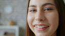 Close-up of a young woman smiling with a blurred indoor background